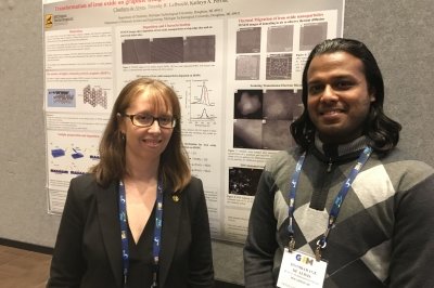 Kathryn Perrine and Chathura de Alwis in front of a research poster.
